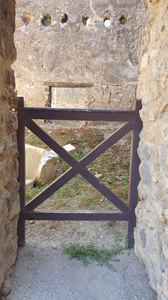 VII.9.3 Pompeii. August 2021. Looking east through doorway in south-east corner.
Foto Annette Haug, ERC Grant 681269 DÉCOR.
According to Fiorelli –
“A small door in the aedicule to the right of the atrium gave entrance to some adjoining rooms, communicating with those of the adjoining temple, and with an exit into the same “blind alley”.
(Una porticina che trovasi nell’edicola a destra dell’Atrio, dava adito ad alcune celle annesse, comunicanti con quelle del tempio adiacente, e con uscita nello stesso angiporto.)
See Pappalardo, U., 2001. La Descrizione di Pompei per Giuseppe Fiorelli (1875). Napoli: Massa Editore. (p.104-105).