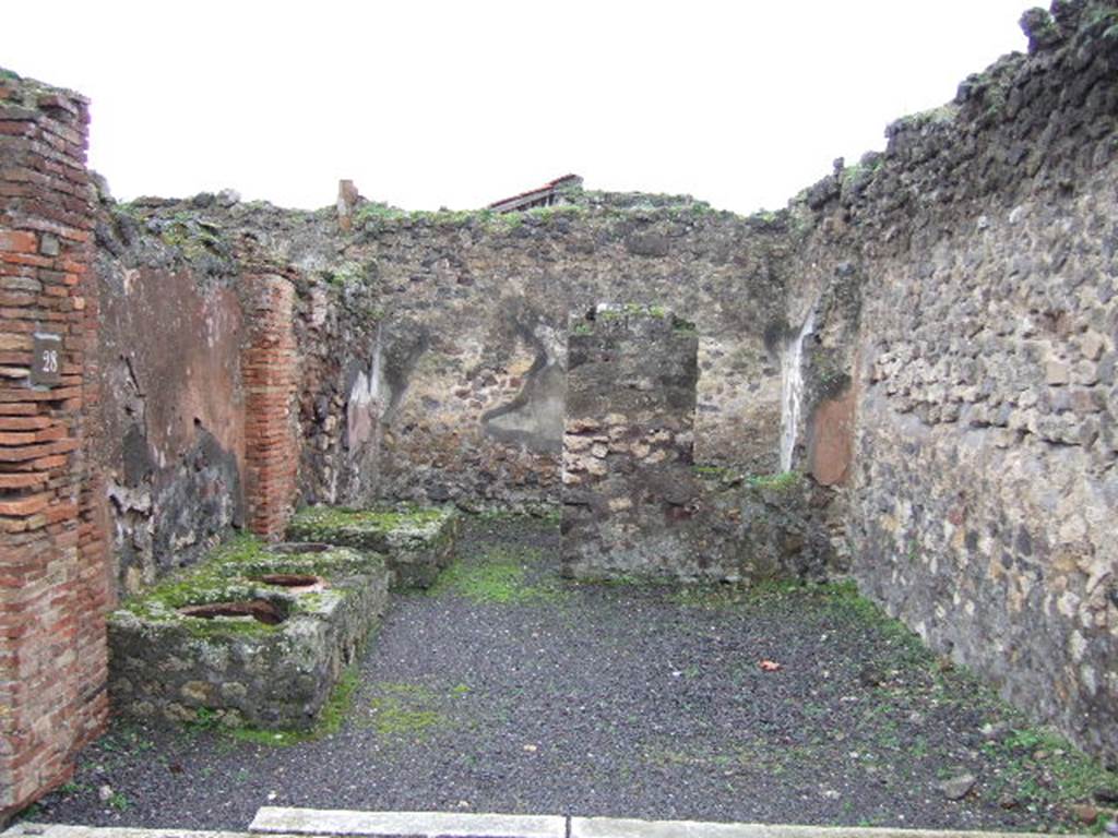 VII.9.28 Pompeii. December 2005. Looking south, on the left is a masonry counter with 3 urns against the east wall. At the rear of the counter is a water basin and doorway to the rear room with a window in its north wall, on the right.