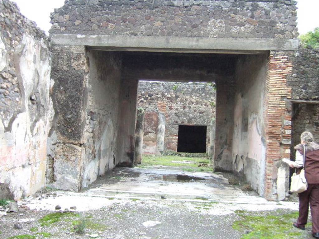 VII.10.3 Pompeii. December 2005. Room 7, looking east across tablinum, from atrium.
According to Breton, the tablinum was completely open onto the atrium and at the rear onto the peristyle. The floor was mosaic. The wall painting on the right (south) wall was preserved. In the red side panels of the south wall were paintings of two women holding masks. In the centre on a white panel was a painting of Bacchus finding sleeping Ariadne on the isle of Naxos. The painting from the left (north wall) no longer existed.
See Breton, Ernest. 1870. Pompeia, Guide de visite a Pompei, 3rd ed. Paris, Guerin.
See Helbig, W., 1868. Wandgemälde der vom Vesuv verschütteten Städte Campaniens. Leipzig: Breitkopf und Härtel. (874,881)
According to Amoroso, on the south wall the central panel had a blue background and in the side red panels were paintings of the muses, Melpomene (on the east end) and Thalia (on the west end). When redecorated the tablinum received a new mosaic floor, with a motif in the centre separated by a double black line of mosaics. At the atrium end (west end), the tablinum floor was separated from the atrium floor by a mosaic of twining ivy plants and leaves enclosed by black lines on the white background.(see fig 35b, on p.107) (p.75)
Studi della Soprintendenza archeologica di Pompei, 22: l”Insula VII, 10 di Pompei, by Angelo Amoroso, (p.75, figs 16,1 and 16,2)