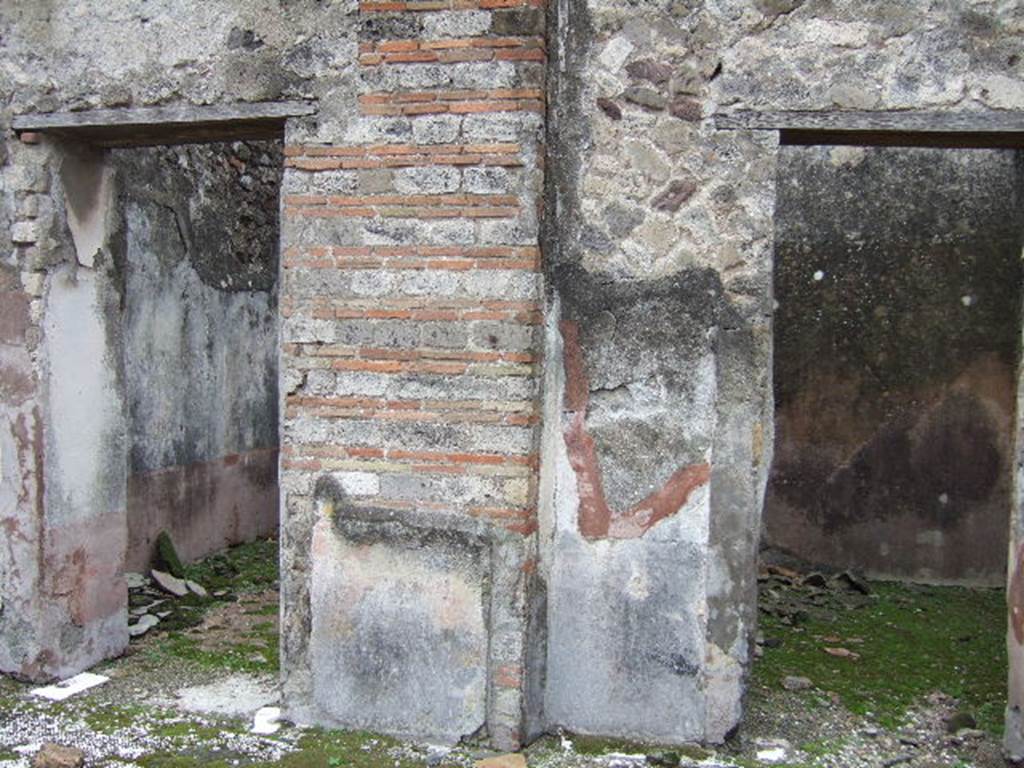 VII.10.3 Pompeii. December 2005. Doorways to rooms 10 and 11, cubiculi on south side of atrium. Both of these rooms also had flooring of red cocciopesto. The doorway, on the left, had a threshold formed by two rectangular limestone slabs, marked in the centre with a circular recess for the closing fixing for the double-set of doors.
Studi della Soprintendenza archeologica di Pompei, 22: l”Insula VII, 10 di Pompei , by Angelo Amoroso. (p.55)