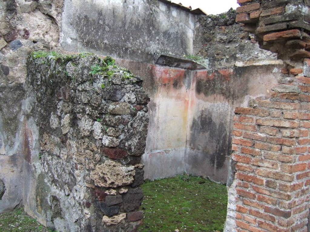 VII.10.3 Pompeii. December 2005. Doorway to room 12, on west side of atrium.
According to Amoroso, this may have been a cubiculum, or even a small oecus. (p.58)
The floor of this room was formed of mosaic, with white tesserae and probably a border of black tesserae.(p.74) The threshold was made from a square, formed by black mosaic lines between which was embedded a black diamond shape on a white background. The walls were renovated with IVth style paintings, the dark zoccolo showed red divisions, in which were painted plants. The middle zone of each wall showed red and yellow vertical panels.
In the central panel was a painting of the attributes of a divinity, the side panels showed pinakes with landscape paintings. The top of the walls had a white stucco cornice, preserved only in the south-west corner. The attributes of Diana, now faded and lost, were shown in a painting on the north wall, and objects sacred to Dionysius were painted on the west wall.
Studi della Soprintendenza archeologica di Pompei, 22: l”Insula VII, 10 di Pompei , by Angelo Amoroso. (p.58 and p.74).
According to Helbig, this room contained paintings of two chariots.
See Helbig, W., 1868. Wandgemälde der vom Vesuv verschütteten Städte Campaniens. Leipzig: Breitkopf und Härtel. (246, 596)
