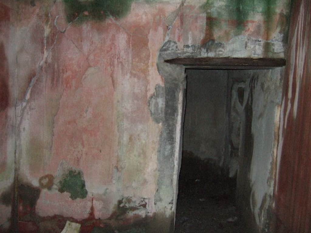 VII.10.3 Pompeii. December 2005. Room 15, looking east into room 16. The doorway to room 14 is on the far right in room 16. According to Breton, this was a well-decorated area, with a doorway from the peristyle, as well as one from the exedra, room 14.
According to Amoroso, this was repainted with new IVth style decorations.
The red zoccolo was divided into small partitions by black cornices and borders of yellow connected by small garlands. In the centre was a painted stylized griffin. The middle zone showed two red panels with black borders, separated by a yellow strip with architectural paintings, at the base of which was a predella edged with a red cornice in which a panther could be seen. The second room, room 16, also had new IVth style decoration with black zoccolo, on which were painted vertical squares painted in white and yellow.
Studi della Soprintendenza archeologica di Pompei, 22: l”Insula VII, 10 di Pompei, by Angelo Amoroso, (p.77)