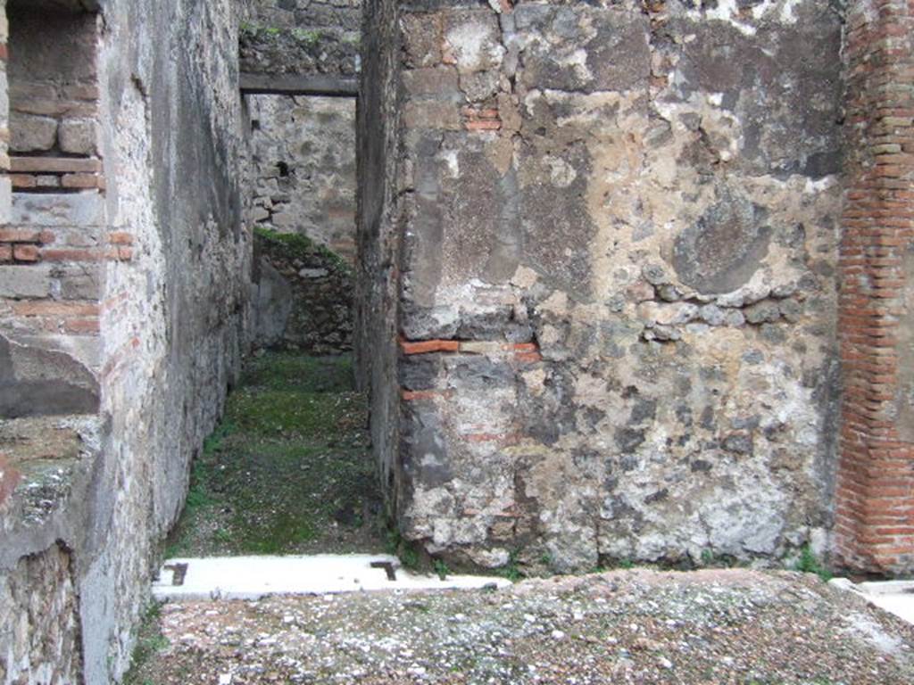 VII.10.5 Pompeii. December 2005. Looking north along passageway leading to kitchen, latrine and storeroom and rear doorway at VII.10.8