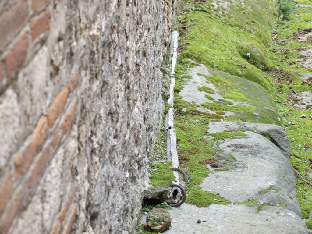VII.10.9 Pompeii. March 2009. Lead pipe in pavement outside entrance, in Vicolo del Balcone Pensile.
