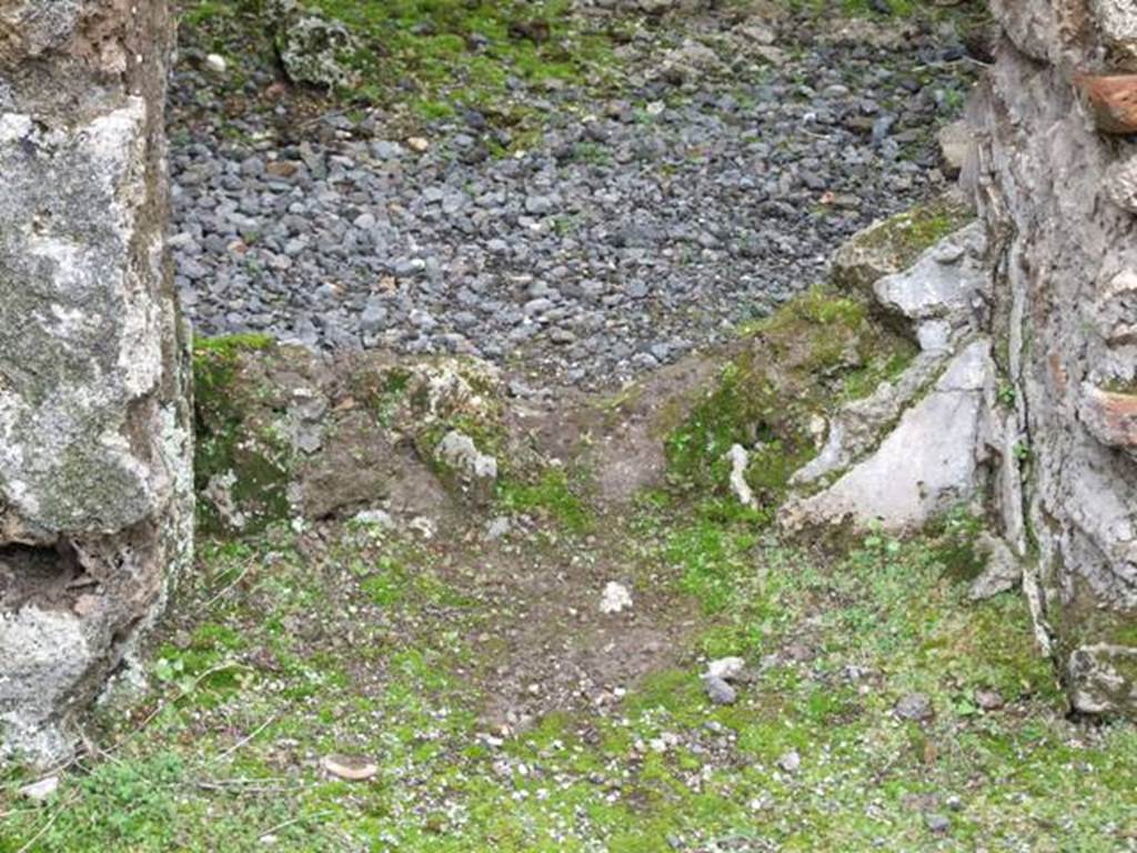 VII.10.12 Pompeii. March 2009. Looking west at wall with a door with plaster in the lower area.