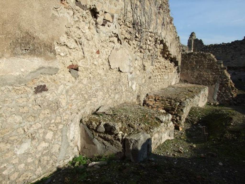 VII.11.3 Pompeii. December 2007. North wall with long podium with hearth and space for cauldron or tub. According to Della Corte, this surely must have been a fullonica. See Della Corte, M., 1965. Case ed Abitanti di Pompei. Napoli: Fausto Fiorentino. (p. 205)