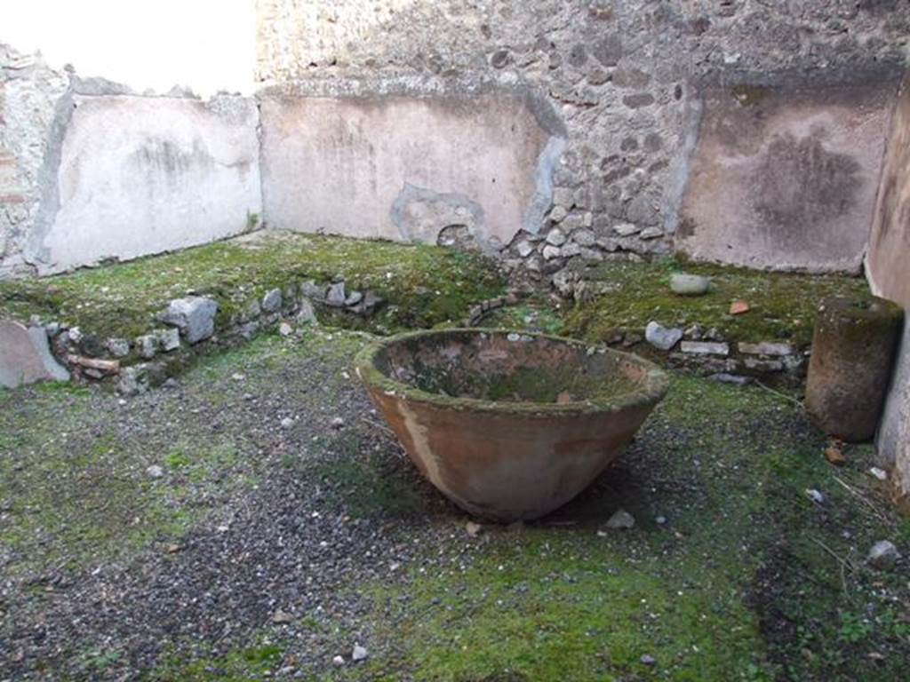 VII.11.5 Pompeii. December 2007. Podium with remains of hearth and large terracotta pot for washing the cloth.