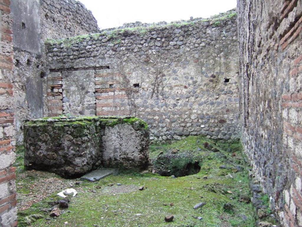 VII.11.7 Pompeii. December 2005. Looking south from entrance.
According to Liselotte Eschebach, this is a stable with livestock watering and feeding rack.
To the right are holes for brackets, also large beam hole.
In the middle is a large round masonry vat or trough, next to it a well.
See Eschebach, L., 1993. Gebäudeverzeichnis und Stadtplan der antiken Stadt Pompeji. Köln: Böhlau, p. 323.
According to PPM, this was a Caupona, originally dependent on the house and communicating with it through a door in the rear room.
The shop, in the centre, had a counter for serving wine, with an adjoining hearth.
See Carratelli, G. P., 1990-2003. Pompei: Pitture e Mosaici. Roma: Istituto della enciclopedia italiana., VII, p. 453-5.
