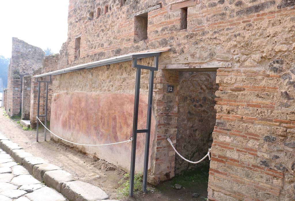 VII.11.12, Pompeii. December 2018.
Looking south to entrance doorway on west side of Vicolo del Lupanare. Photo courtesy of Aude Durand.