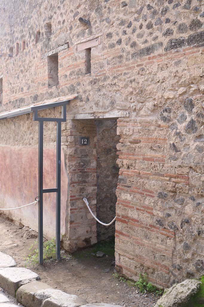 VII.11.12, Pompeii. December 2018.
Entrance doorway, with phallus in wall above. Photo courtesy of Aude Durand.