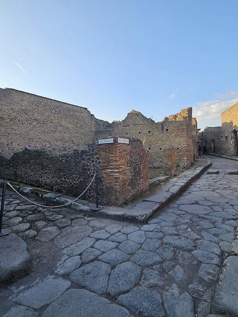 VII.11.17 and 16 Pompeii. November 2024.
Looking north from junction to entrance doorways on Vicolo del Lupanare, in centre.
Vicolo degli Scheletri is on the left. Photo courtesy of Annette Haug.