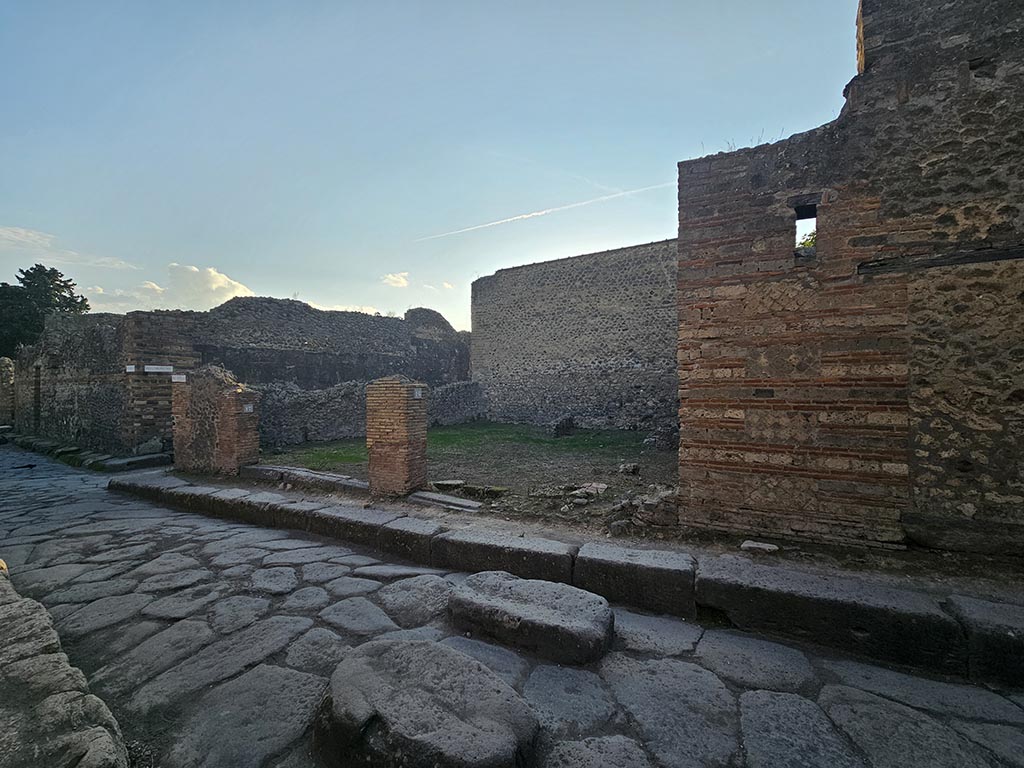 VII.11.17 and 16 Pompeii. November 2024.
Looking south-west from Vicolo del Lupanare towards two shops at junction with Vicolo degli Scheletri, on left.
Photo courtesy of Annette Haug.