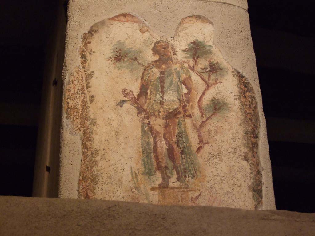 VII.12.18 Pompeii. December 2006.
Wall painting of Priapus in front of a fig tree, with double phallus, from the upper frieze in the middle of the north wall.