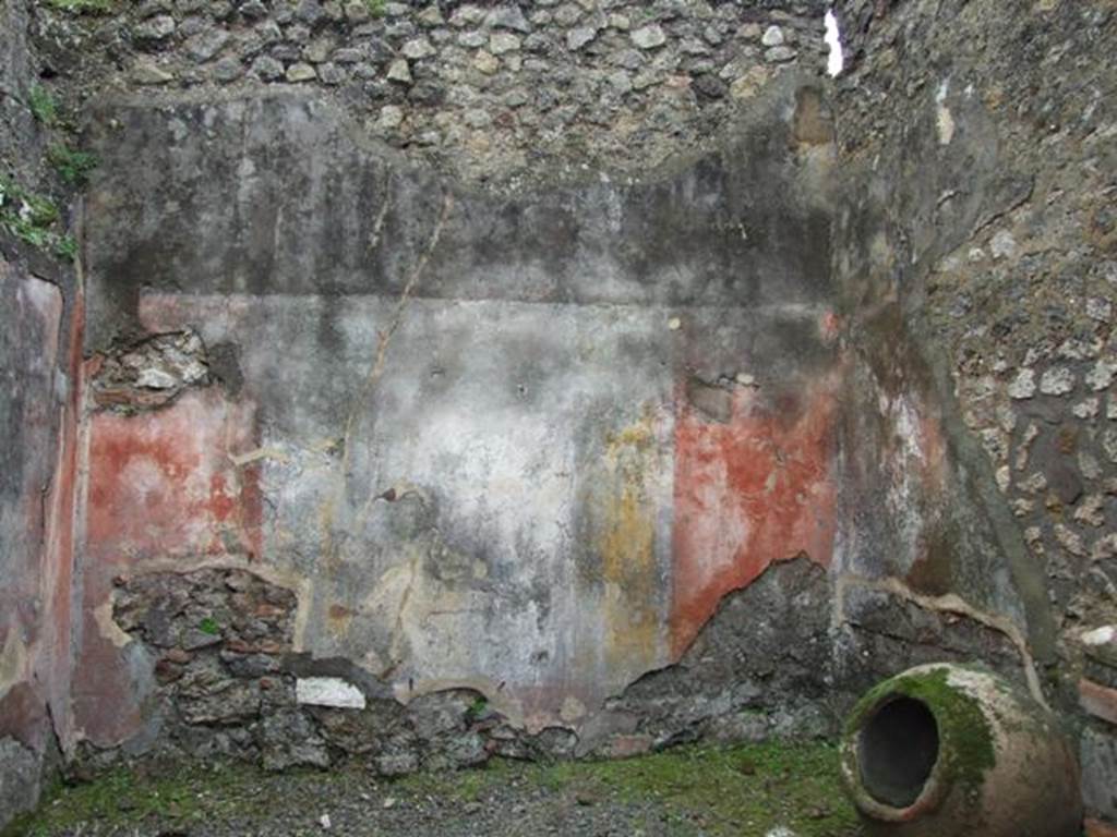 VII.14.5 Pompeii. March 2009. Room 13, south wall with remaining painted plaster.
The wall would have been painted in the IV Style, with red panels framed by “carpet” borders and two parallel lines.
The borders would have been separated by architectural decoration which showed, according to Fiorelli, three paintings with fish and landscape.
No trace of these paintings survives on the south wall.