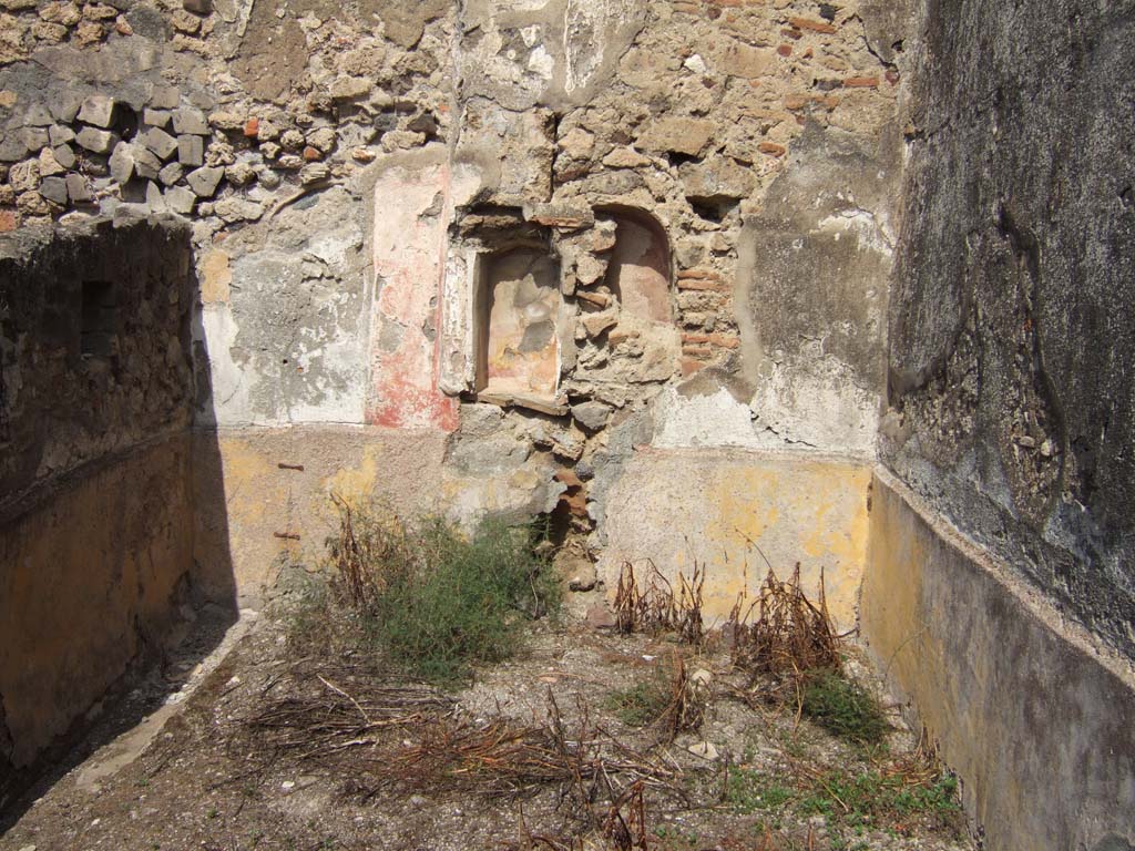 VII.15.5 Pompeii. September 2005. North wall of small garden with niches and site of cylindrical altar and lararium painting.
Boyce recorded a rectangular niche and his plate showed a plastered wall to the right of it which presumably covered the second niche.
In front he recorded a cylindrical altar of about 0.5m height covered in stucco painted in imitation red and white marble.
See Boyce G. K., 1937. Corpus of the Lararia of Pompeii. Rome: MAAR 14. (p. 72, no.330, plate 12,3).