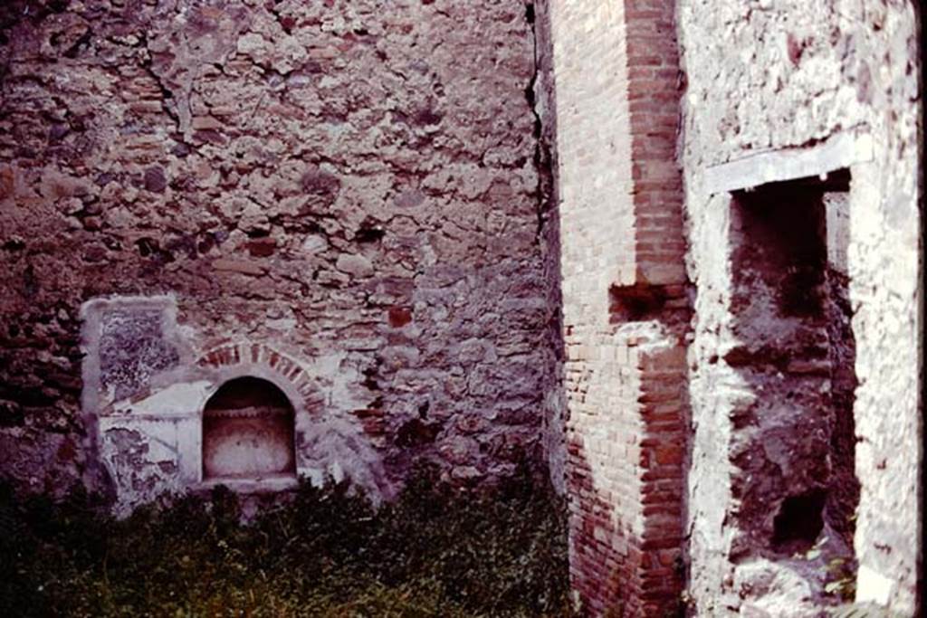 VII.15.8 Pompeii, 1978. Looking towards niche in north wall of garden area. Photo by Stanley A. Jashemski.
Source: The Wilhelmina and Stanley A. Jashemski archive in the University of Maryland Library, Special Collections (See collection page) and made available under the Creative Commons Attribution-Non Commercial License v.4. See Licence and use details. J78f0238
According to Boyce, in the centre of the north wall of the garden area near the floor, was an arched niche. The wall around it was covered with a rectangular panel of white stucco. On this was an aedicula façade which was marked off with yellow and violet lines in low relief. The work was delicately executed but somewhat irregular.
See Boyce G. K., 1937. Corpus of the Lararia of Pompeii. Rome: MAAR 14. (p.72, no.332, Pl.6,2)