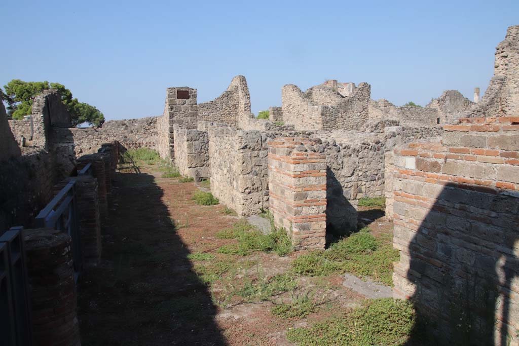 VII.16.1-4 Pompeii. September 2021.
Looking west along portico with entrance doorway VII.16.1, left of centre, and VII.16.4, on right. Photo courtesy of Klaus Heese.