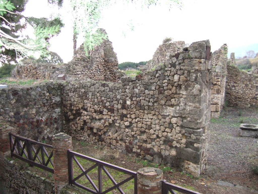 VII.16.1 Pompeii. September 2005. Looking north-west from Temple of Venus towards entrance doorway, on right. On the left behind the wall would have been the area of the portico and peristyle. According to Garcia y Garcia, this house was badly hit by the bombing on 13th September 1943. The bombing totally demolished the atrium, five annexed rooms on the north and east sides, and the portico near the baths. The impluvium has now totally vanished. In many ways, the restoration of 1950 has changed and distorted the original plan of the house. The stairs on the north-west side of the atrium and the portico have vanished. The baths of the house are now accessible only from no.12. Near the baths was a portico of fourteen columns. The portico does not exist anymore, erased by the bombardment.
See Garcia y Garcia, L., 2006. Danni di guerra a Pompei. Rome: L’Erma di Bretschneider. (p.130-1)
According to Jashemski, the peristyle garden was reached by a short flight of steps, at the left west rear of the atrium. It was enclosed by a portico on the south, east and north, supported by columns.
See Jashemski, W. F., 1993. The Gardens of Pompeii, Volume II: Appendices. New York: Caratzas. (p.201)