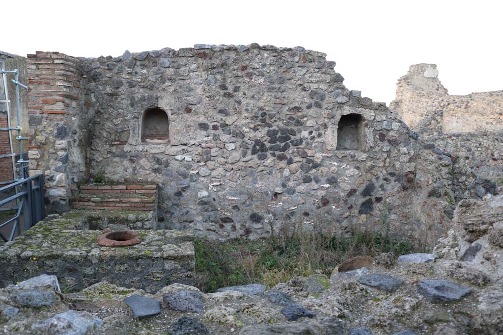 VII.16.7 Pompeii. December 2018.
Looking west towards entrance doorway, on left, counter with display shelves and inset urn/s, and west wall with two niches.
Photo courtesy of Aude Durand.
