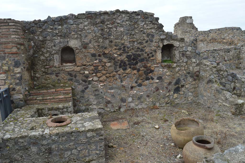 VII.16.7 Pompeii. March 2018.
Looking west towards entrance doorway, on left, counter with display shelves and inset urn/s, and west wall with two niches.
Foto Taylor Lauritsen, ERC Grant 681269 DÉCOR.