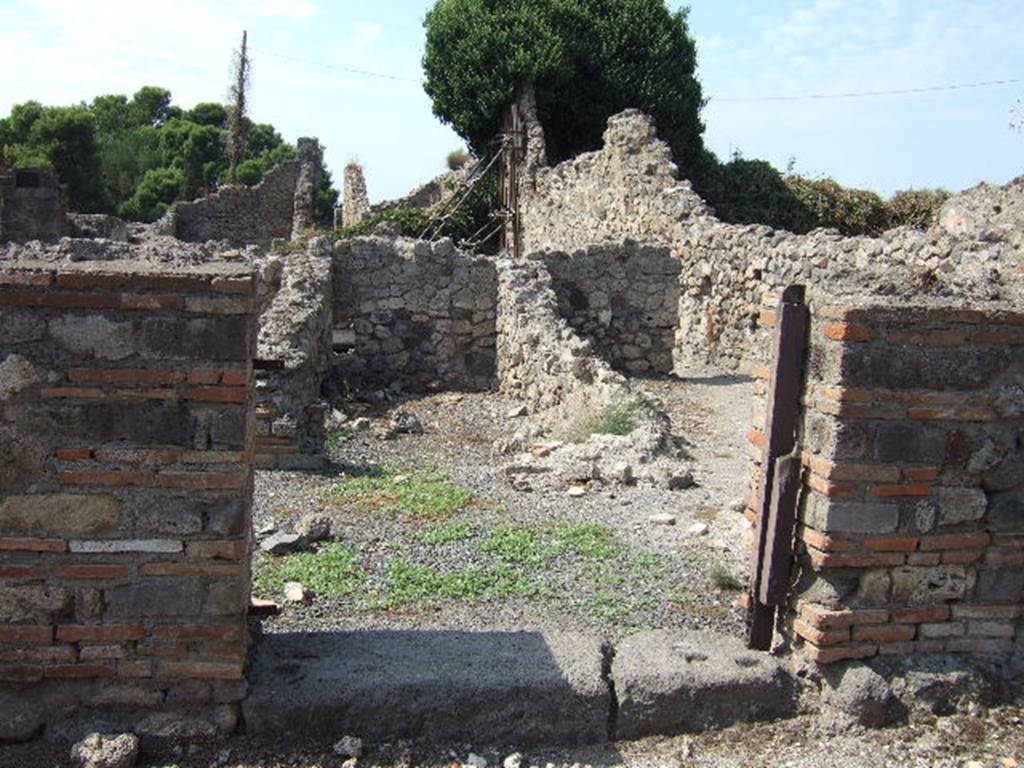 VII.16.9 Pompeii. September 2005. Looking west through entrance doorway.
According to Fiorelli –
“In questo trovasi innanzi tutto un forno, separato da altre localita cui prima stava congiunto, e con due celle adiacenti, una delle quali servita certamente di apotheca.”
See Pappalardo, U., 2001. La Descrizione di Pompei per Giuseppe Fiorelli (1875). Napoli: Massa Editore. (p.161)
(translation: An oven was found in this, separated from other places with which it had been first joined, and with two adjacent rooms, one of which would have certainly been used as a storeroom/cupboard.”)