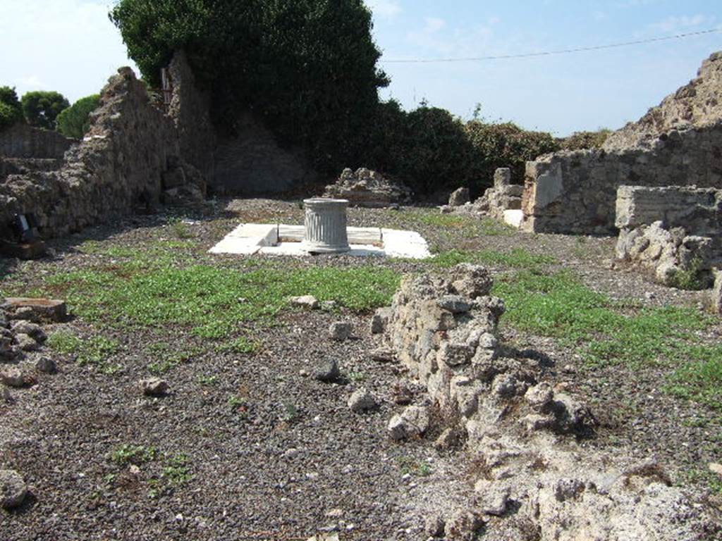 VII.16.10 Pompeii. September 2005. Looking west across atrium to rear.
The tablinum would have been in the south-west corner, in the rear left.
The oecus would have been in the north-west corner, in the rear right behind the room with the white marble threshold. According to Garcia y Garcia “Excavation of the Prince of Montenegro”. When the house was excavated in 1851 it showed important decoration in the III style in the 2 rooms to the west of the atrium, the tablinum and an oecus. The walls of the tablinum were protected from the moisture through the isolation achieved with big tegulae mammatae on which the plaster was applied.
This was then frescoed. At the moment of excavation in 1851, the detachment of one of these large tegula (tegoloni) collapsed half of the west wall. This wall was painted with a scene of Europa on the bull (fig 312-3, page 132). The 1943 bombardment provoked the total destruction of the atrium and some surrounding rooms, with the total loss of the decorations in III and IV style. In the succeeding restoration of 1950, the entrance threshold (fig 314) was recovered, and the impluvium was also restored (fig 315-6). However, there are some elements that are lost, for example the stairs of which Fiorelli spoke.
Some others have been arbitrarily modified, the for example the changing of the entrance at no.11.
See Garcia y Garcia, L., 2006. Danni di guerra a Pompei. Rome: L’Erma di Bretschneider. (pp.133, 199-200, figs 312-6, 465)