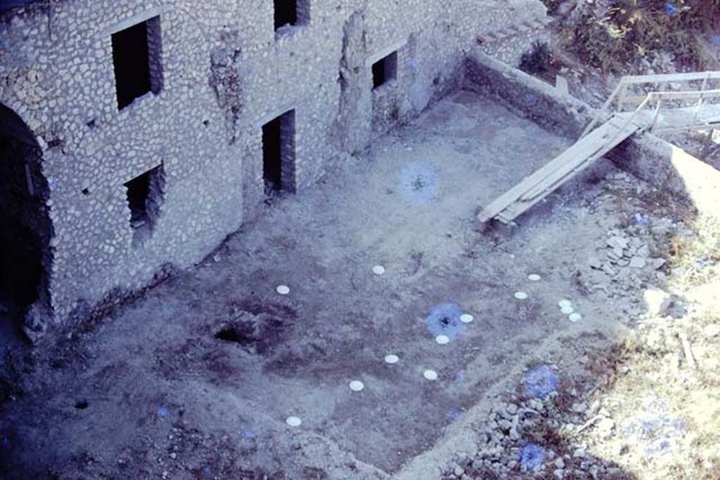 VII.16.17, Pompeii. 1974. Looking south-west from the courtyard garden, down onto lower garden. According to Jashemski, the garden was badly damaged and piled with building debris in 1974, but in the south part they were able to find root cavites (the white markers) arranged informally in rows. Photo by Stanley A. Jashemski.
Source: The Wilhelmina and Stanley A. Jashemski archive in the University of Maryland Library, Special Collections (See collection page) and made available under the Creative Commons Attribution-Non Commercial License v.4. See Licence and use details. J74f0706