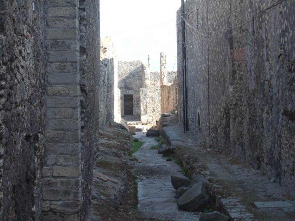VII.6 Pompeii. September 2005. Vicolo del Farmacista, looking south. VII.16 on right. According to Garcia y Garcia, in 1943 the internal unexcavated area between VII.16. A and B (20 and 21) along the Vicolo del Farmacista was hit by a bomb. It fell on the soil not yet excavated and demolished the perimeter wall for a length of 4m x 3m and a part of the escarpment in two areas for 8 metres..
See Garcia y Garcia, L., 2006. Danni di guerra a Pompei. Rome: L’Erma di Bretschneider. (p.137)
