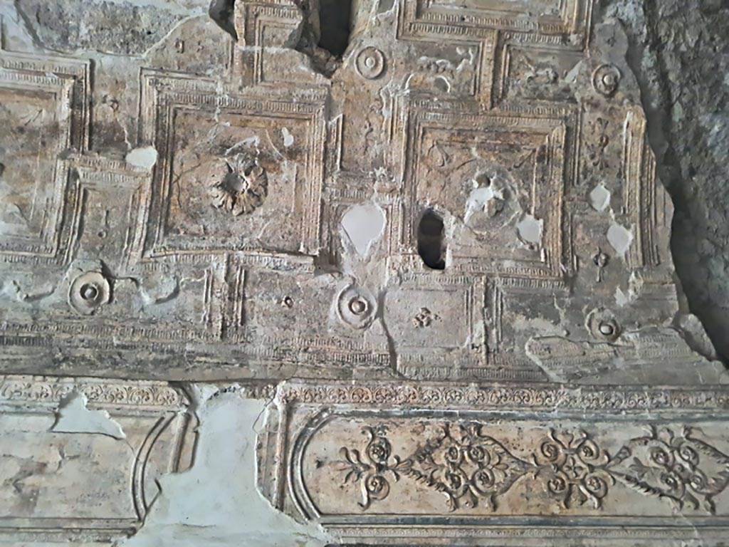 VII.16.a Pompeii. November 2023.
Room 6, detail of decorative stucco above doorway to room 7 on south wall, in south-west corner. Photo courtesy of Giuseppe Ciaramella.