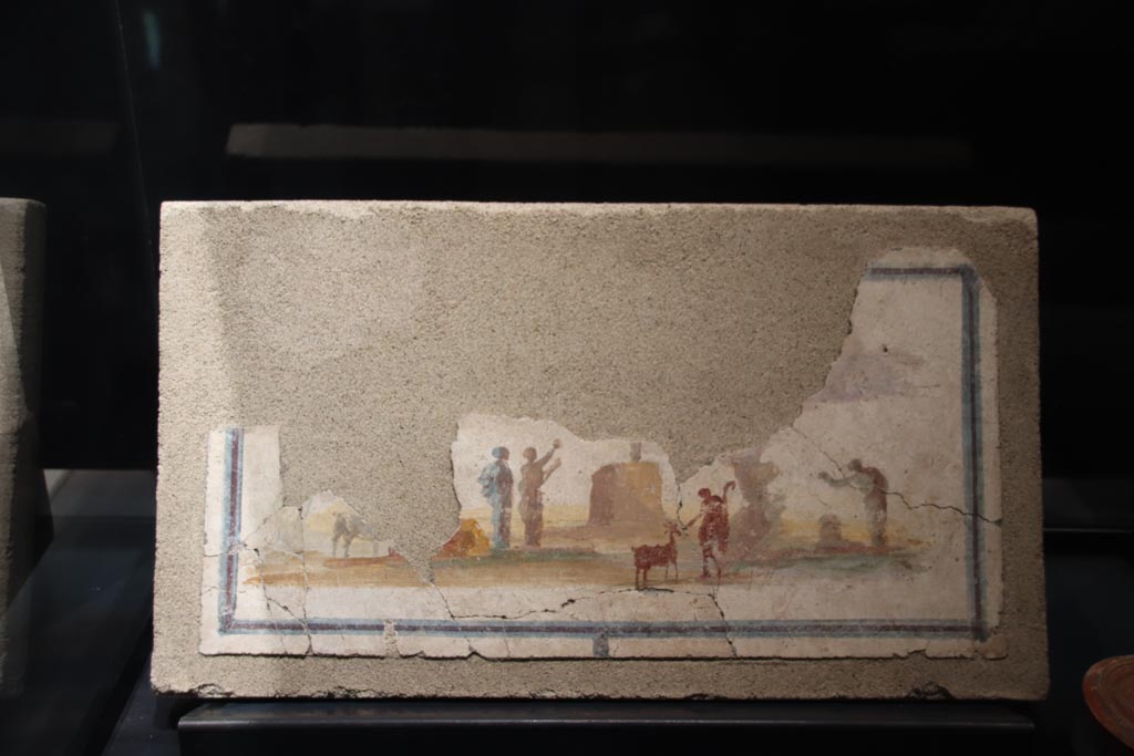VII.16.a Pompeii. May 2024.
Painting of idyllic sacred landscape on display in exhibition in palaestra, entitled “L’altra Pompei, vite comuni all’ombra del Vesuvio”.
Photo courtesy of Klaus Heese.