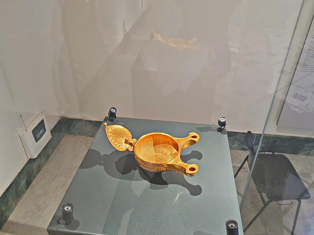 VIII.1.3 Pompeii. April 2023. Gold lamp with two nozzles donated as a gift to the Temple.
On display in “Campania Romana” gallery in Naples Archaeological Museum, inv. 25000. Photo courtesy of Giuseppe Ciaramella.
