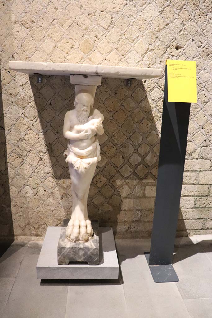 VIII.1.4 Pompeii Antiquarium. February 2021.
Marble monopodium, with Silenus and Dionysus as a baby, found in VI.15.8.
Photo courtesy of Fabien Bièvre-Perrin (CC BY-NC-SA).