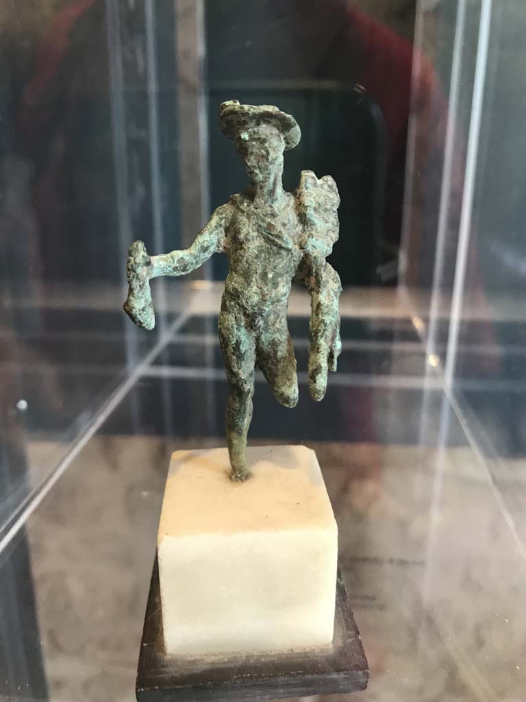 VIII.2.1 Pompeii. April 2019.
Bronze statuette of Mercury carrying a money bag. Found in the area to the south of the House of Championnet.
Pompeii Inventory number 6331. Photo courtesy of Rick Bauer.
According to Zanella -
This statuette was found in Room B, the triclinium on the lower floor of VIII.2.3-5 (or room belonging to VIII.2.14-16) on 9th February 1937.
See Zanella S., 2019. La caccia fu buona: Pour une histoire des fouilles à Pompéi de Titus à l’Europe. Naples : Centre Jean Bérard, (p.268).