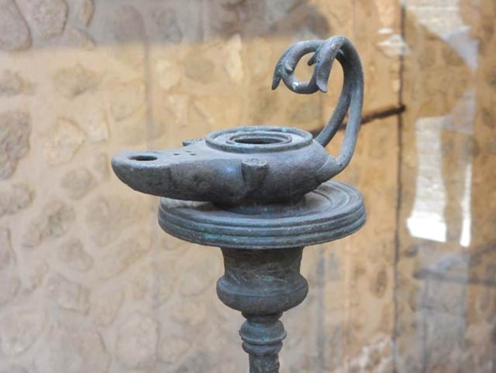 VIII.2.1 Pompeii. May 2018. Bronze lamp at the top of a tall lamp stand.
Photo courtesy of Buzz Ferebee.