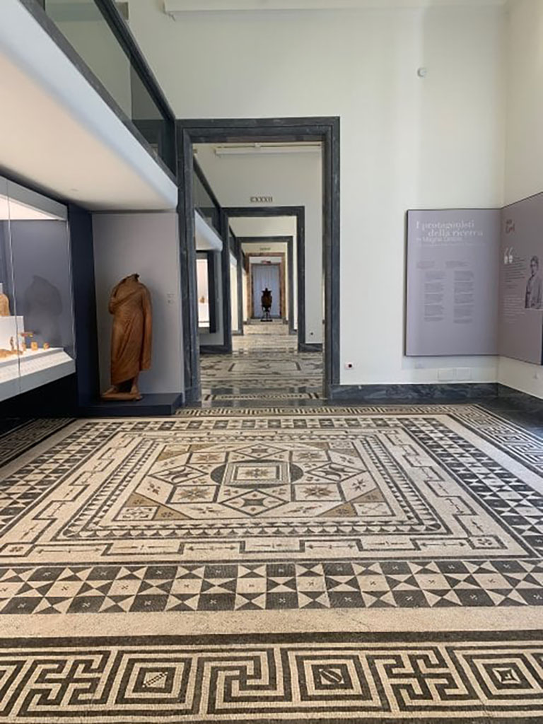 VIII.2.1 Pompeii, or Villa Urbana, Varano, Stabia. Mosaic on floor in Naples Museum.
According to Zanella –
This mosaic, shown on page 107, fig.49, a drawing by L. Destouches, 1816-1817; (collection Pierre Pinon); is described as being from Casa di Championnet.
See Zanella S., 2019. La caccia fu buona: Pour une histoire des fouilles à Pompéi de Titus à l’Europe. Naples : Centre Jean Bérard, (P.107).
The meander band surrounding the edge of the mosaic floor is thought to be from a room in the Secondo Complesso at Stabia
See Pisapia, floor no. 124 in centre from Villa Urbana, Stabia, with meander border no. 112 around edge.
See Pisapia, M. S. 1989, in Mosaici antichi in Italia, Regione prima. Stabia, Roma, (p.56 for no. 112, and p.67-70, for no.124).