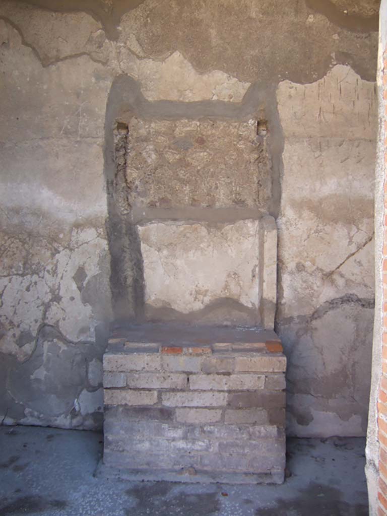 VIII.2.16 Pompeii. September 2005. Remains of aedicula household shrine.
According to Boyce, in the third small room on the south of the atrium, against the south wall stand the ruins of an aedicula.
A masonry podium that was ornamented along the upper edge with a stucco cornice, supported the shrine.
The shrine was built of tufa and coated with white stucco contemporary with the walls of the room.
This was spread not long before the catastrophe.
The inside of the aedicula was divided into two storeys, each supported by two columns and two antae.
The roof was flat and adorned with terracotta antefixes.
One of these was preserved and represented a male face in the centre of a kind of palmette.
Nearby was found a small tufa altar.
See Notizie degli Scavi di Antichità, 1893, p. 48.
See Boyce G. K., 1937. Corpus of the Lararia of Pompeii. Rome: MAAR 14. (p.74, no.343)