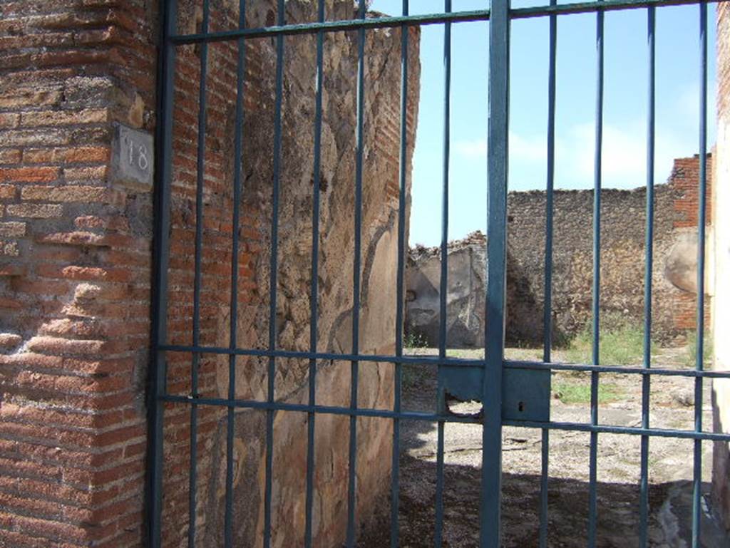 VIII.2.18 Pompeii. September 2005. Doorway and south side of entrance corridor.
According to PPM –
“The walls of the vestibule were in “opus reticulatum” of excellent workmanship, and with brick door-jambs.
The walls were decorated in the IV Style with a high red zoccolo/plinth/dado painted with panels bordered in a “carpet” design edged with triangles.
The middle areas of the walls were painted black. The mosaic flooring was of large black tiles/tesserae.”
See Carratelli, G. P., 1990-2003. Pompei: Pitture e Mosaici: Vol. VIII. Roma: Istituto della enciclopedia italiana, (p.115, no.34)
