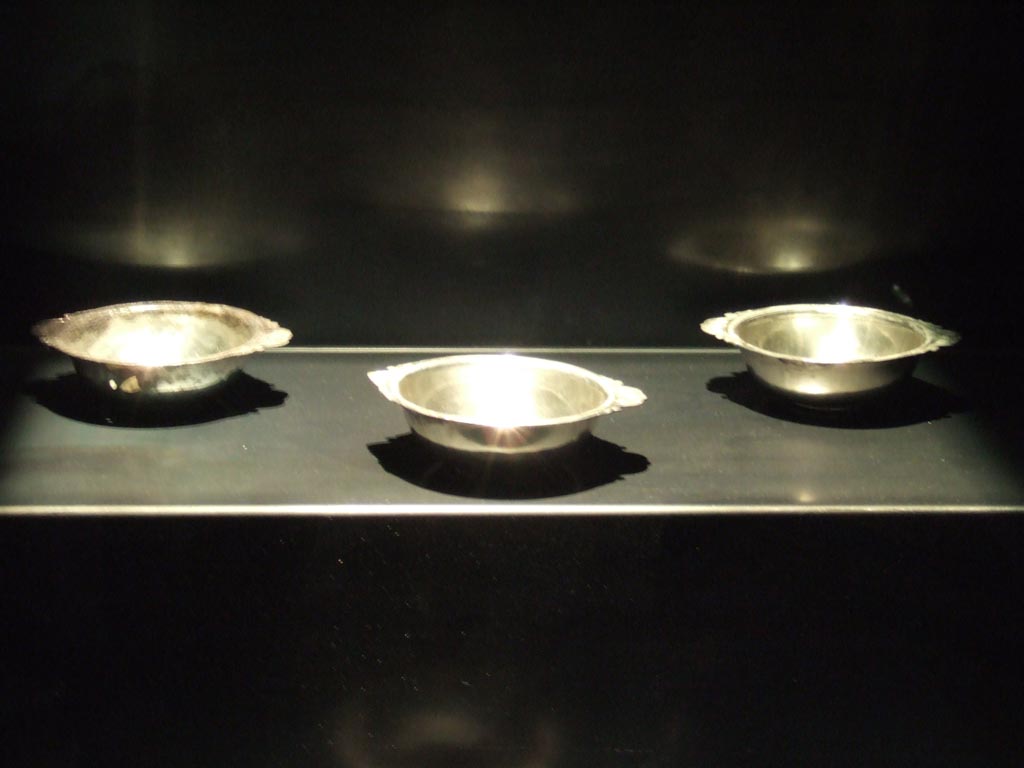 Silver plates, three of four found 20th September 1887 in VIII.2.23.
Now in Naples Archaeological Museum. Inventory numbers 116337, 116338 and 116340.
See Guzzo, P. (A cura di), 2006. Argenti a Pompei. Milano, Electa. (p. 133).