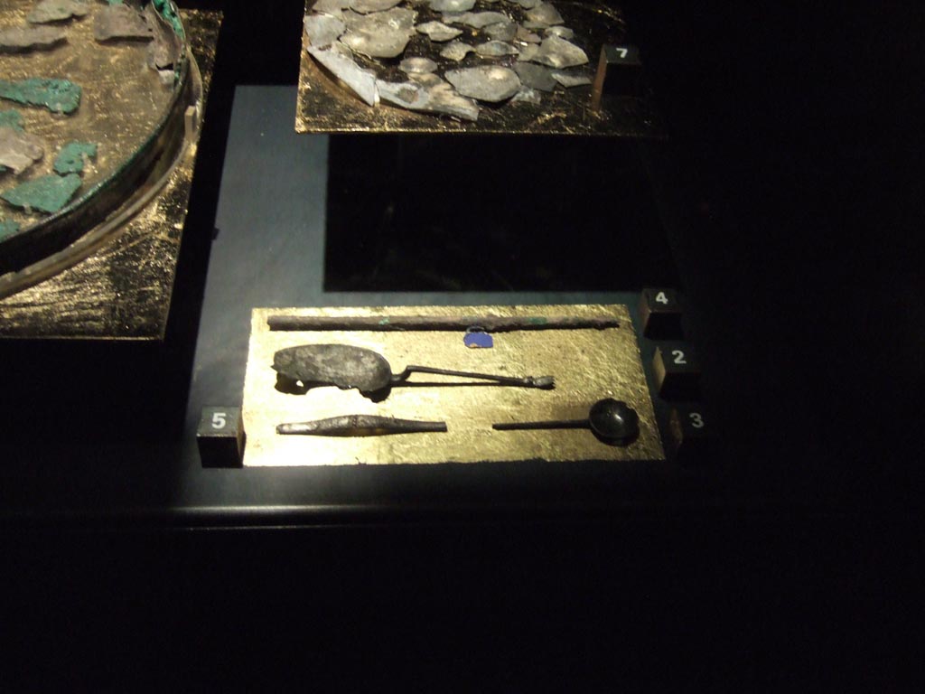 Four silver items found 20th September 1887 in VIII.2.23. Now in Naples Archaeological Museum.
Fragment of a wine tube (top). Inventory number 116360.
Oval spoon with raised handle (centre). Inventory number 116357.
Fragment of a long handle probably of a simpulum (bottom left). Inventory number 116362.
Round spoon (bottom right). Inventory number 116358.
See Guzzo, P. (A cura di), 2006. Argenti a Pompei. Milano, Electa. (p. 134).