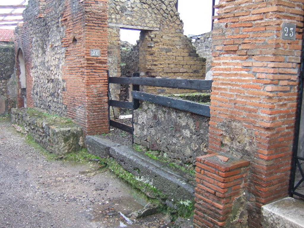 VIII.2.24 Pompeii. December 2004. Looking east to doorway, and bench outside. In the east wall of the bar can be seen a doorway, this led into the kitchen with hearth and latrine. See Eschebach, L., 1993. Gebäudeverzeichnis und Stadtplan der antiken Stadt Pompeji. Köln: Böhlau. (p.358)