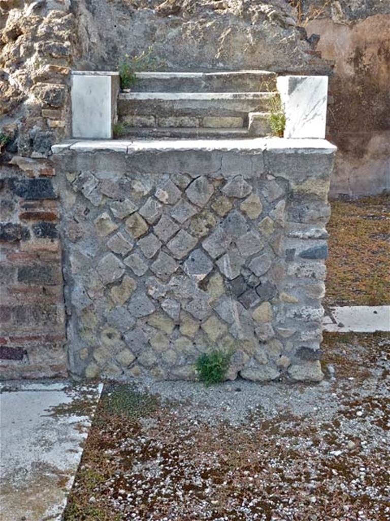 VIII.2.28 Pompeii. September 2011. Base of Lararium.
In the north-west corner of the atrium is a masonry base. This was the lararium.
The top of it had three small steps of marble (see below).
The aedicula that was originally on the base has disappeared.
On the north wall above the base, when excavated, the figures of the Lares could still be seen.
See Boyce G. K., 1937. Corpus of the Lararia of Pompeii. Rome: MAAR 14. (p74, no.345)
According to NdS –
“The base was faced with plaster imitating coloured marble, on top of which were three small steps recovered with precious coloured marble.”
See Notizie degli Scavi di Antichità, 1887, (p.511).