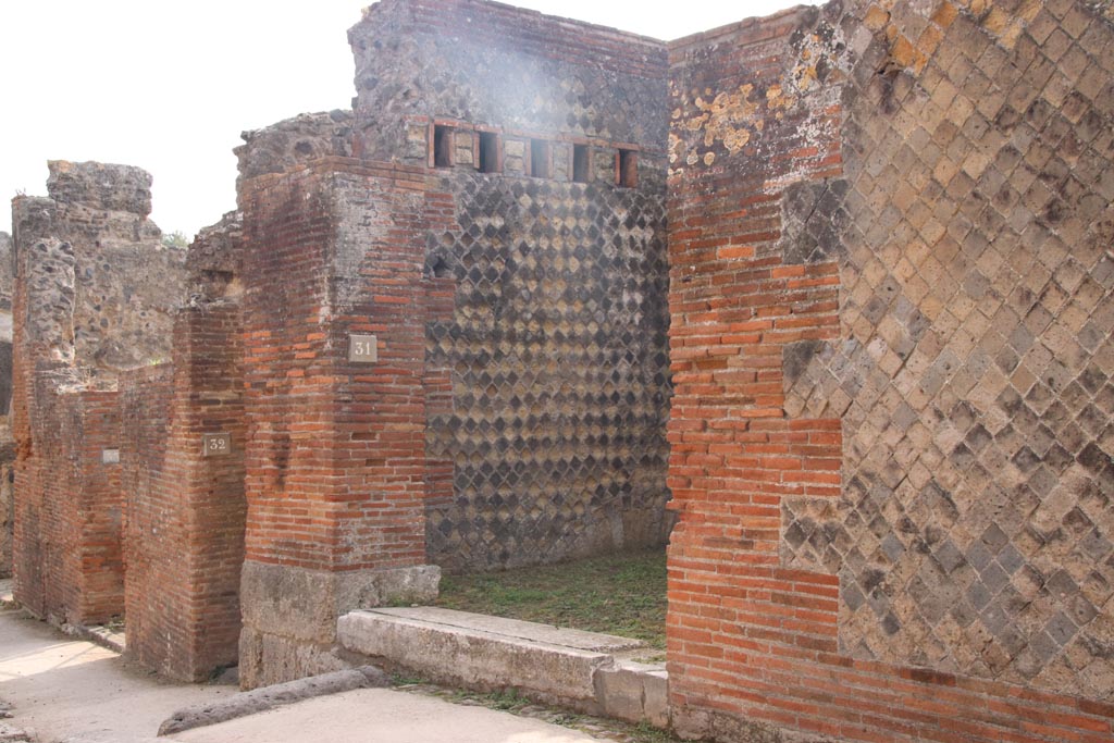 VIII.2.31 Pompeii. October 2023.
Looking east along south side of Via della Regina towards entrance doorways. Photo courtesy of Klaus Heese.