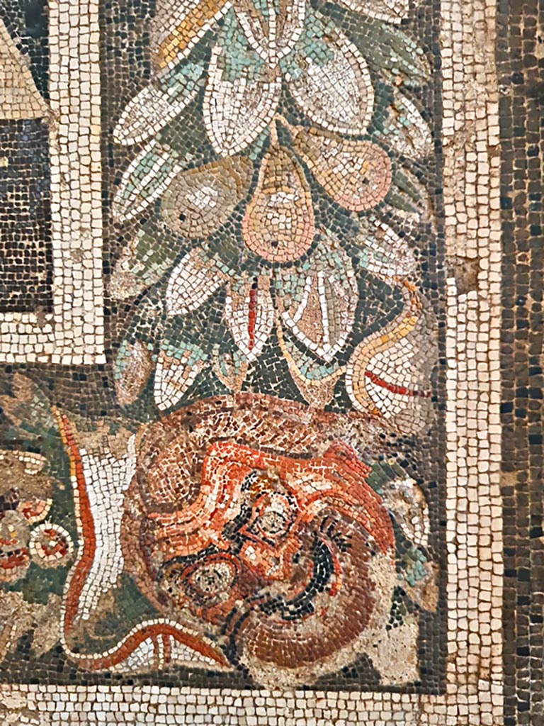 VIII.2.34 Pompeii. Detail of border-edge of mosaic showing mask, and garland with fruit.
Now in Naples Archaeological Museum. Inventory number 114281. Photo courtesy of Giuseppe Ciaramella. September 2024.