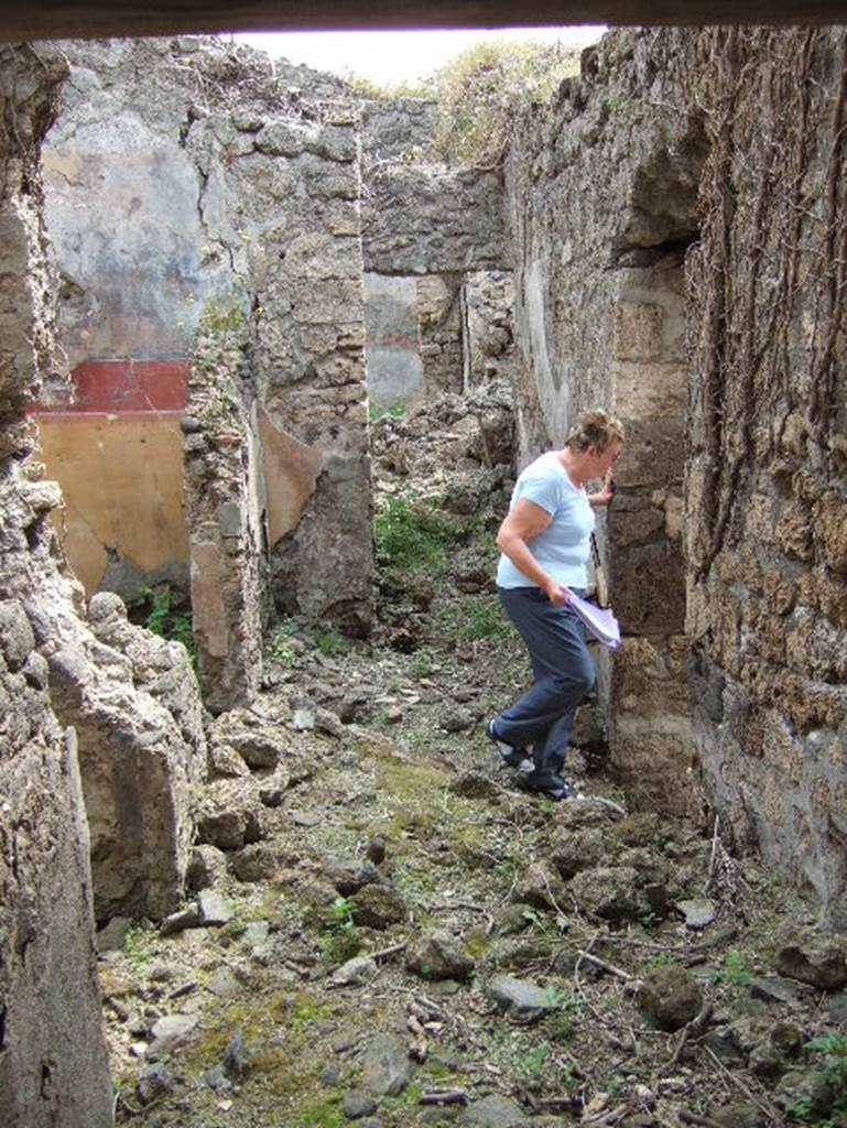 VIII.2.34 Pompeii. May 2006. Looking east across corridor ‘5’ of rear lower level rooms.
On the left is the doorway to room ‘1’, followed by room ‘2’ with the yellow, red and black wall decoration. Behind the painted east wall of room ‘2’, would be ‘room 3’, and at the end of the corridor would be room ‘5’, facing the camera.