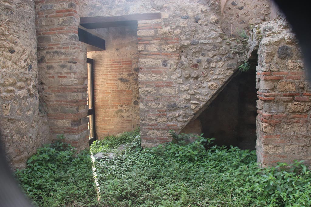 VIII.2.38 Pompeii. October 2023.
Looking south to doorway to kitchen and steps to upper floor, with recess below. Photo courtesy of Klaus Heese.