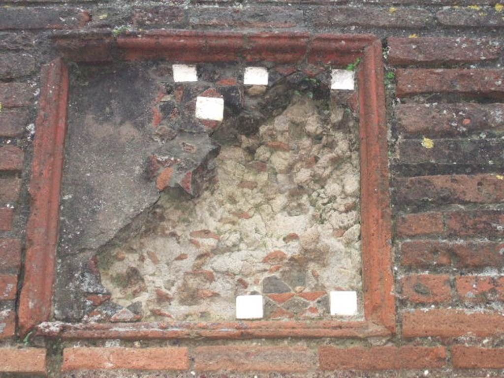 VIII.3.5 Pompeii. December 2005. Remains of plaque with pieces of tessellated stone and mosaic on wall between VIII.3.6 and VIII.3.5.