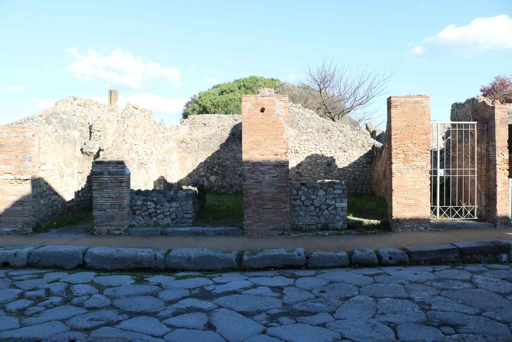 VIII.3.24 Pompeii, on left, VIII.3.23, VIII.3.22, and VIII.3.21, on right. December 2018.
Looking east to entrance doorways from Via delle Scuole. Photo courtesy of Aude Durand.
