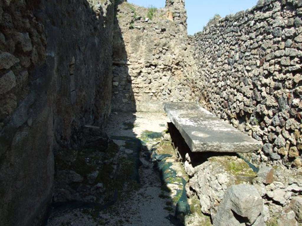 VIII.4.4 Pompeii. March 2009. Room 7, kitchen, with small basin and long marble top. Looking north. The kitchen contained not only a hearth, worktable and latrine, but also three basins or masonry structures.
A fourth structure or basin in the peristyle colonnade was connected to the kitchen through an opening.