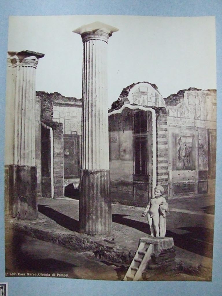 VIII.4.4 Pompeii. Fountain and south portico of peristyle. Old undated photograph number 489.
Courtesy of Society of Antiquaries, Fox Collection.
According to Dyer:
“Two of the rooms on the further side of the peristyle, and at the extremity of the house, are visible in this view.
The smaller one, on the left, appears to be a bedchamber.
The floor is of opus Signinum; the walls painted mostly red and yellow, apart from the usual architectural ornaments, also have pictures of Nereids riding through the waves on sea-monsters.
The picture facing the entrance, so far as can be made out, represented the Dioscuri.
Next to this room, on the right, is a large and handsome exedra, or retiring room.
It is paved with black and white marble and has in its middle a small impluvium or basin; from which we may infer that there was a corresponding aperture in the roof.
The walls were adorned with small but well-executed pictures.
On the facing wall was Narcissus admiring himself in the fountain.
On the left wall a Hermaphrodite leaning on the shoulder of Silenus could be seen.
On the right wall, Bacchus accompanied by his usual troop, discovering Ariadne.
See Dyer, Thomas, 1867: The Ruins of Pompeii. London: Bell and Daldy, (p.80).