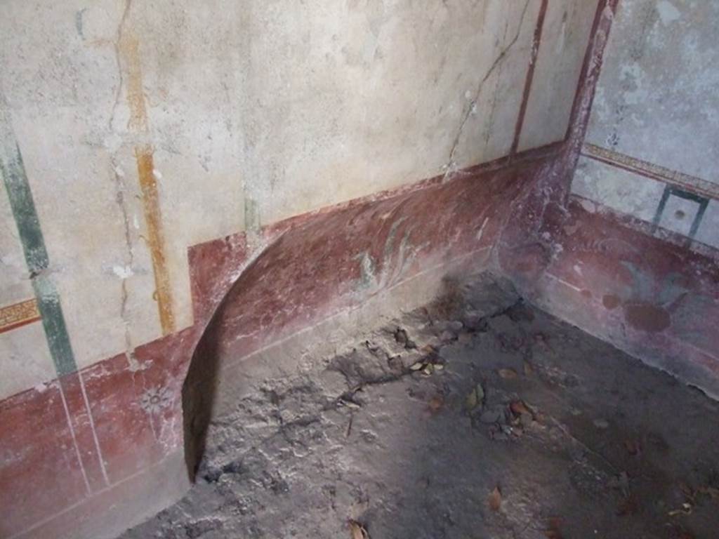 VIII.4.4 Pompeii. March 2009. Room 22, recess in south-west corner of cubiculum. The south wall was decorated with a red plinth, and the red zoccolo had flower motifs in the central panel and painted plants in the side panels. The middle zone of the wall was white, the central panel had a candelabra decoration and the side panels were edged with vertical garlands and borders of “carpet” pattern. The upper wall was painted white.
